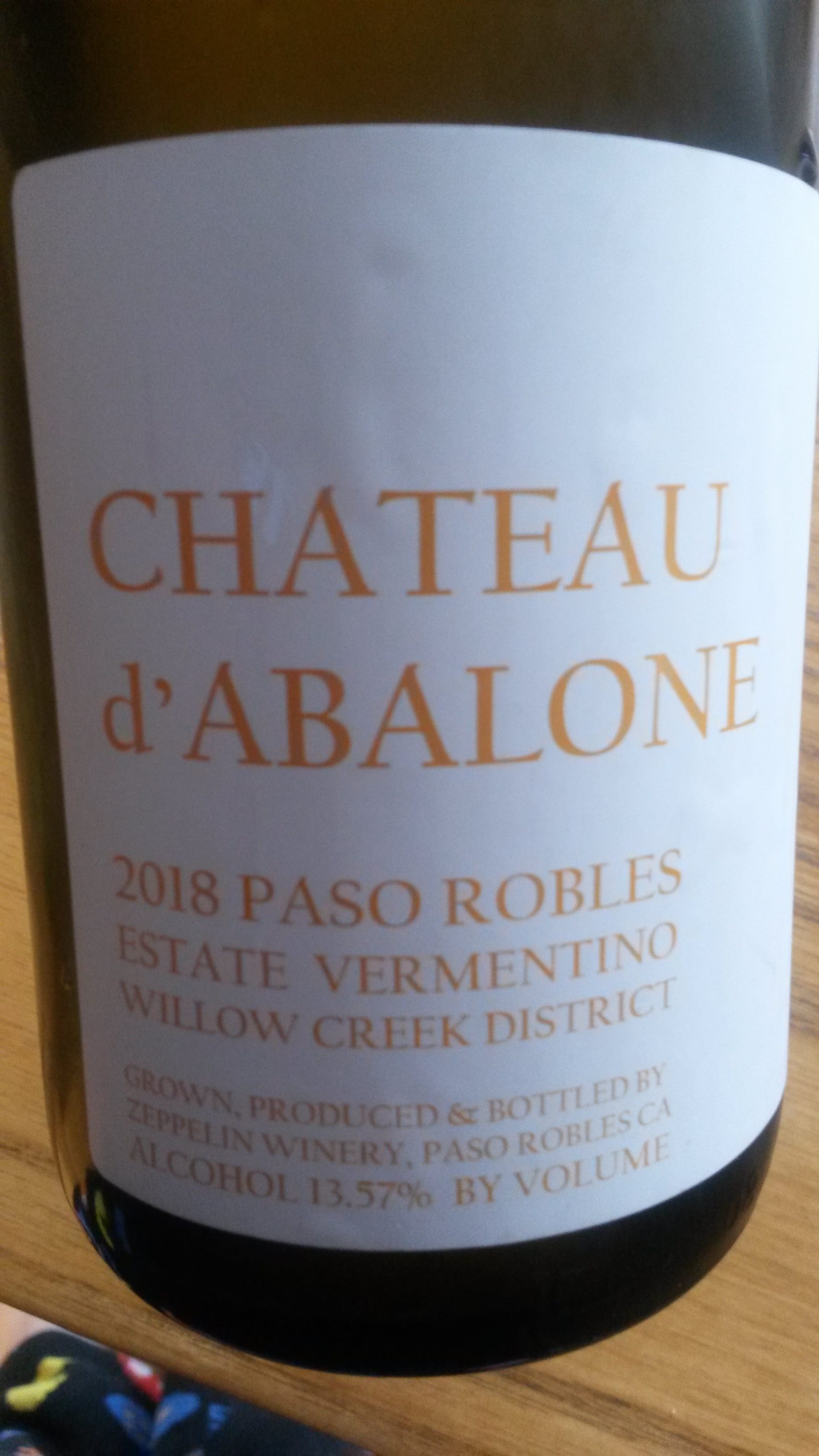 Lots of text on a white label on the wine bottle