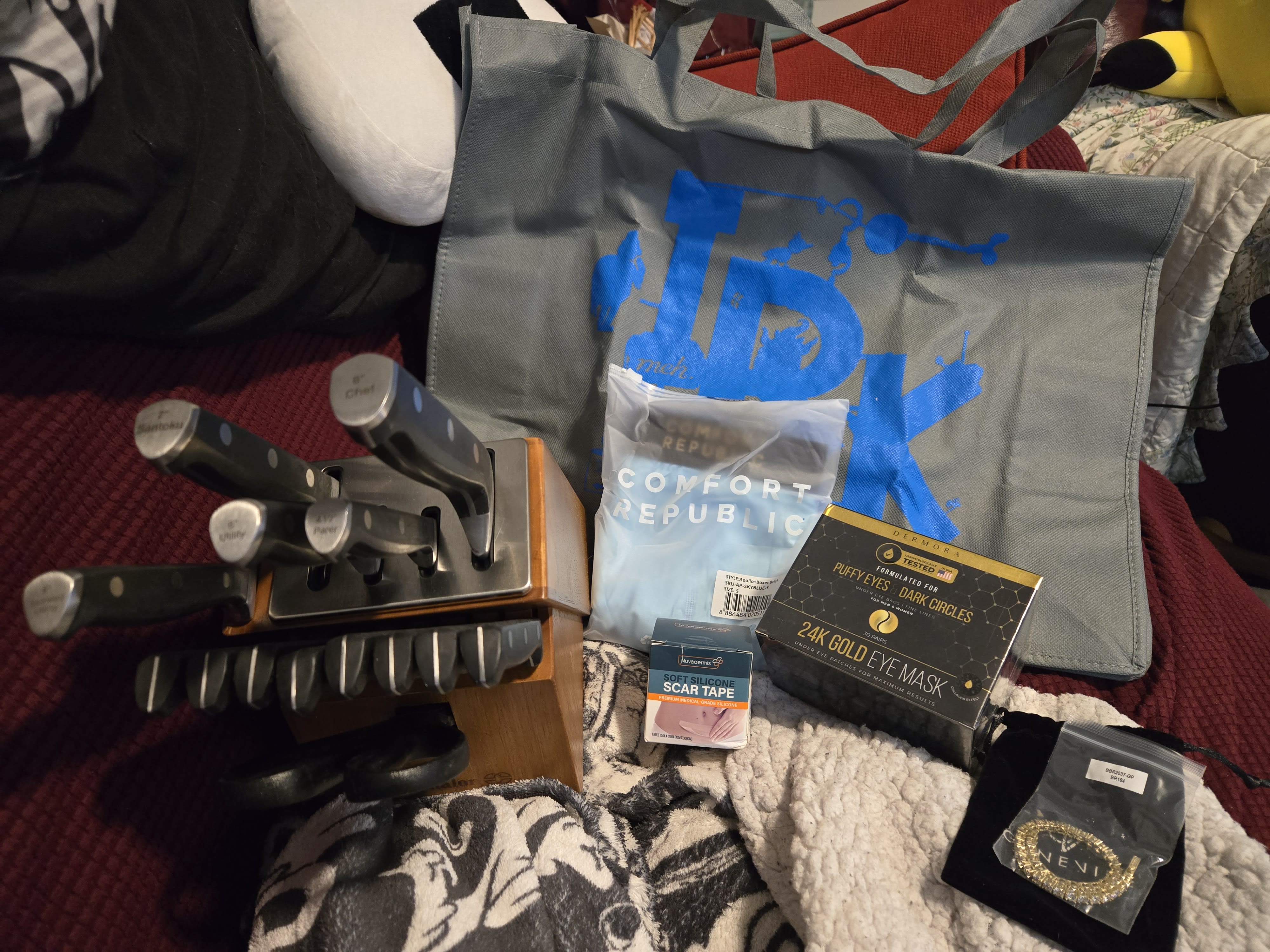 a photo of the above mentioned items piled on a burgundy couch and blankets