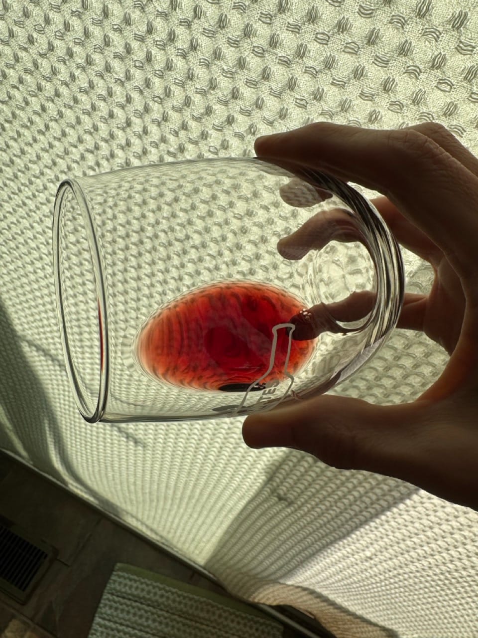 2014 Barone Ricasoli Brolio Chianti Classico Riserva in tilted glass against backlit white curtain