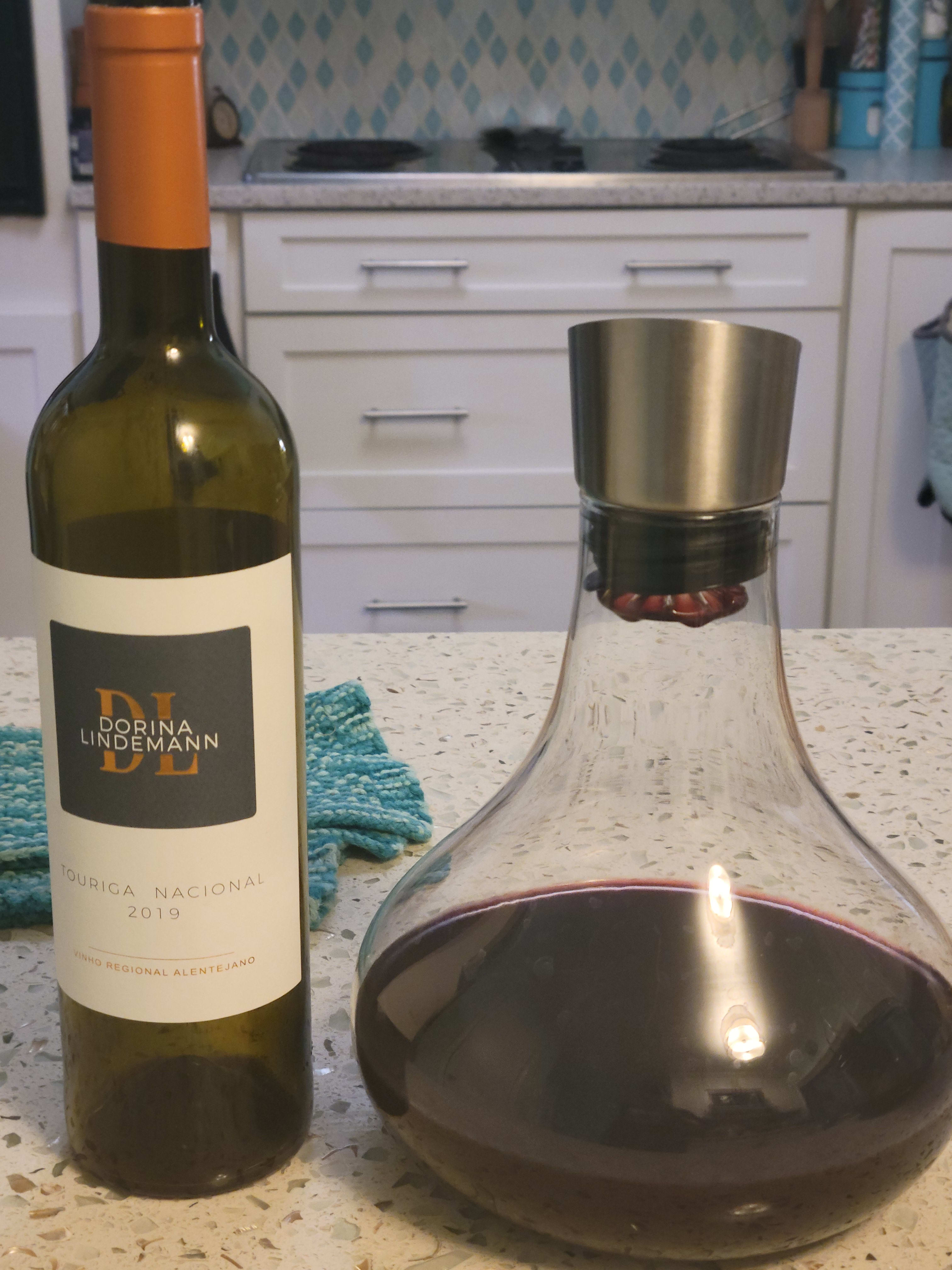 Red wine in a decanter next to the bottle.